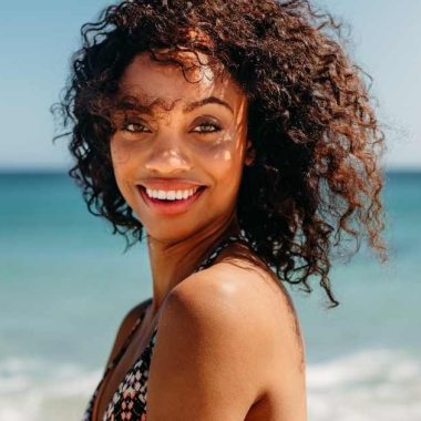 woman with curly hair at the beach