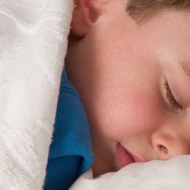 Child sleeping covered with white blanket