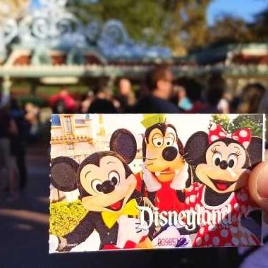 Disneyland Ticket being held in front of the Disneyland entrance