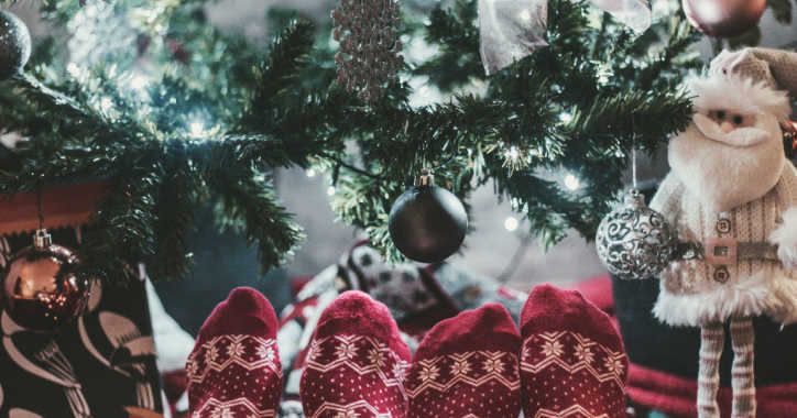Feet in Christmas socks in front of a Christmas tree