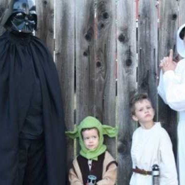 Family dress up like darth vader, yoda, anikin skywalker, and princess leia