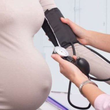 pregnant woman getting blood pressure checked.