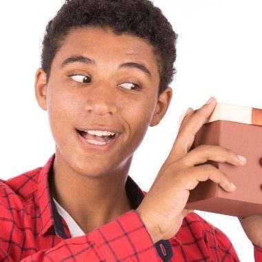 Teen boy shaking gift