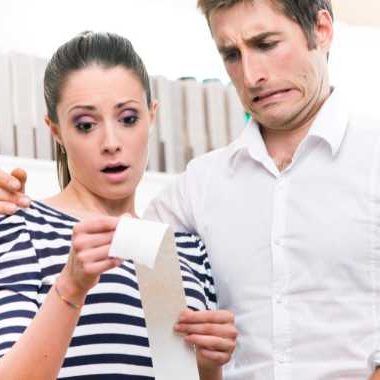 Couple looking concerned at a long receipt.