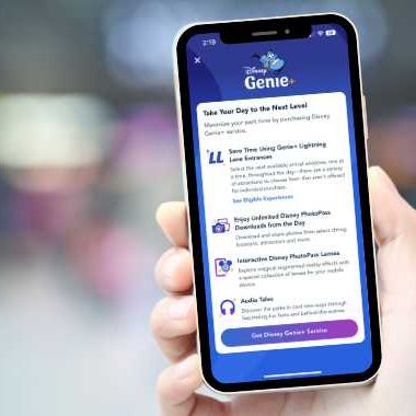 Hand holding a cell phone showing the Disneyland App with Genie+