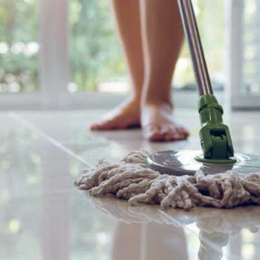 barefoot person mopping tile floors.