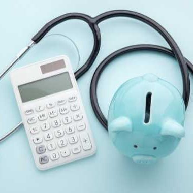 Stethoscope, calculator and piggy bank