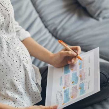 Pregnant woman looking at calendar.