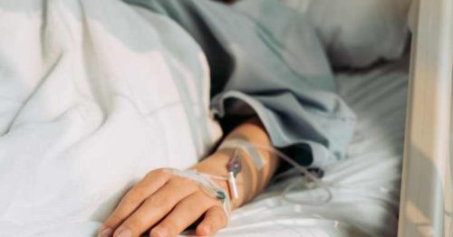 Woman laying in hospital bed with IV