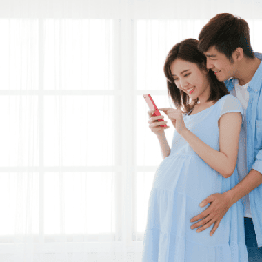 pregnant couple looking at their phone.