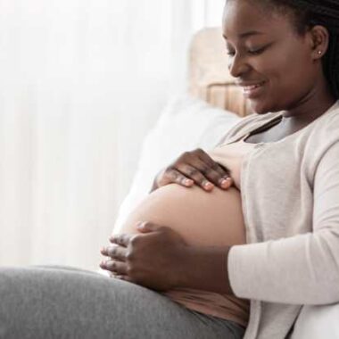 black pregnant woman holding her belly