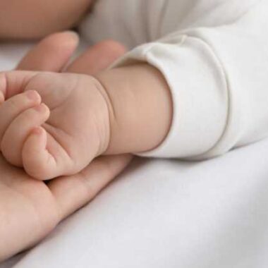 mom holding new baby's hand